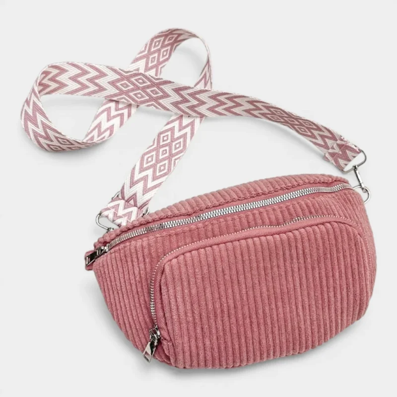 Sac banane velours côtelé rose posé de face, avec sangle jacquard à motif graphique blanc et rose
