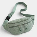 Sac banane velours côtelé vert sauge posé de face, avec sangle unie réglable et bouclerie en plastique