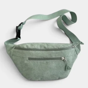 Sac banane velours côtelé vert sauge posé de face, avec sangle ajustable et fermetures zippées apparentes