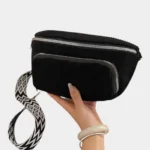 Sac banane velours côtelé noir porté de face, avec sangle jacquard à motif géométrique noir et blanc