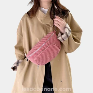 Sac banane velours côtelé rose porté en bandoulière par une femme au style décontracté