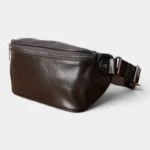 Sac Banane Cuir Vintage Homme Sac banane cuir marron posé de trois quarts, avec fermeture éclair métallique sur la face et sangle à boucle