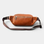 Sac Banane Cuir Vintage Homme Sac banane cuir marron posé de face, avec sangle brune et fermeture éclair en métal devant