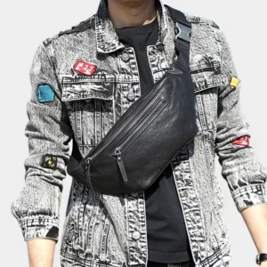 Grand sac banane cuir noir porté en bandoulière par un homme au style rock avec boucle métallique sur la sangle