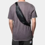 Petit sac banane cuir noir porté en bandoulière dans le dos par un homme, vue arrière