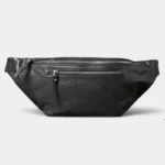 Grand sac banane cuir noir posé de face, avec deux fermetures zippées métalliques apparentes
