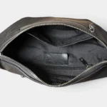 Grand sac banane cuir noir homme face vu de dessus, poche principale ouverte révélant poches zippées intérieures