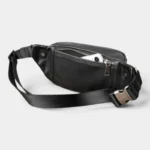 Sac Banane Cuir Vintage Homme Sac banane cuir noir posé vu de face, poche principale ouverte laissant apparaître un smartphone