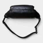 Sac Banane Cuir Noir Homme Souple Sac banane cuir noir homme souple posé à plat vu de dessus, avec sangle réglable et boucle plastique