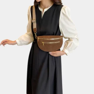 Sac banane marron en simili cuir porté en bandoulière par une femme au style chic avec sangle tressée beige