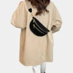 Sac banane noir effet daim porté en bandoulière par une femme de dos, avec sangle à motif tissé