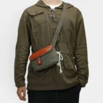 Sac banane rectangulaire cuir kaki porté en bandoulière par un homme, au style vintage militaire
