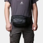 Sac Banane Cuir Noir Homme Souple Sac banane cuir noir porté à la taille par un homme de face au style décontracté