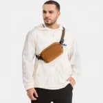 Sac Banane Nylon Imperméable Gorpcore Sac banane nylon camel porté en bandoulière par un homme de face au style gorpcore