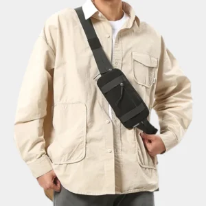 Petit sac banane nylon noir porté en bandoulière par un homme, au style workwear décontracté