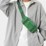 Petit sac banane nylon vert porté en bandoulière par un homme au style casual-oversize