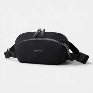 Sac banane nylon noir au style gorpcore, posé de face avec des zips gris anthracite