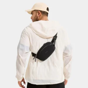 Sac banane nylon noir porté en bandoulière dans le dos par un homme au style gorpcore