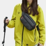 Sac banane nylon ripstop noir porté en bandoulière par une femme de face au style outdoor sportif