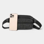 Sac banane nylon à motif grille blanc sur fond noir, posé de face avec un smartphone appuyé contre lui