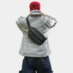 Sac banane nylon ripstop noir porté en bandoulière dans le dos par un homme, vue de dos