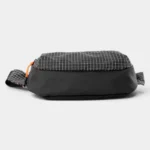 Sac banane nylon ripstop noir à motif quadrillé blanc, posé de côté, avec fermeture éclair orange