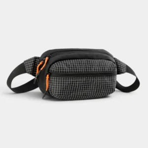 Sac banane nylon ripstop noir à motif grille, posé de trois quarts avec fermetures éclair orange fluo