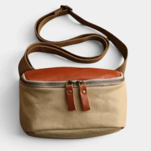 Sac banane en cuir et toile coton beige et miel au style vintage posé de face, avec fermeture zippée à tirants cuir