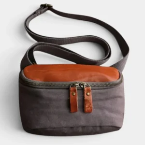 Sac banane rectangulaire cuir et toile coton gris foncé et marron posé de face, avec sangle ajustable sans motif