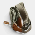 Sac banane extensible en toile verte et cuir véritable posé à plat vue de dessus avec attache en métal
