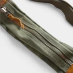 Sac banane extensible toile coton vert kaki au style militaire, gros plan sur la fermeture zippée à tirette cuir