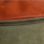 Sac banane cuir marron et toile vert kaki, gros plan sur la matière et la fermeture métal