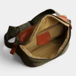 Sac banane rectangulaire en cuir vert kaki vu de dessus, poche principale ouverte avec poches zippées intérieures