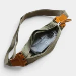 Sac banane en toile coton vert kaki et cuir vu de dessus, poche principale ouverte contenant un smartphone
