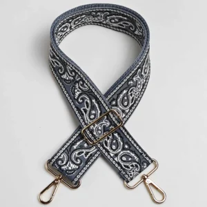 Bandoulière large paisley bandana bleu ardoise à quincaillerie dorée, posée à plat de face avec mousquetons et boucle de réglage