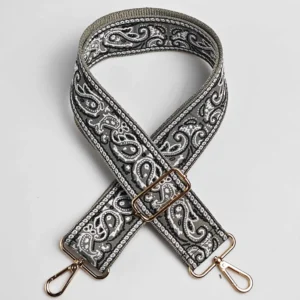 Bandoulière large motif paisley bandana gris anthracite et blanc posée à plat, avec mousquetons et boucle de réglage en métal doré