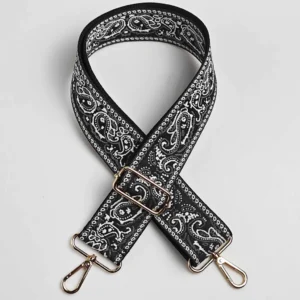Bandoulière large paisley bandana noire et blanche à quincaillerie dorée, posée à plat en croix sur fond neutre