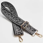 Bandoulière Large Réglable Motif Paisley Bandana Bandoulière large paisley bandana noire à sangle jacquard et quincaillerie dorée, posée à plat vue de face