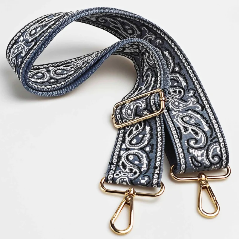 Bandoulière large réglable motif paisley bandana bleu marine en polyester jacquard, posée à plat avec mousquetons et boucle de réglage dorés