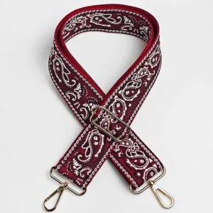 Bandoulière large réglable motif paisley bandana rouge bordeaux à sangle jacquard blanc, boucle et mousquetons dorés, posée à plat de face