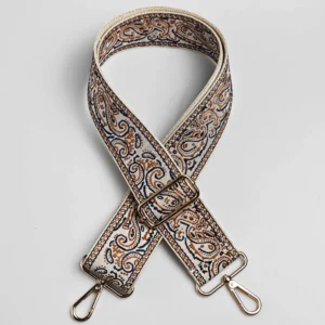 Bandoulière large réglable en polyester jacquard paisley crème et marron, posée à plat avec mousquetons et boucle de réglage dorés
