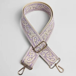 Bandoulière large paisley en polyester jacquard violet lavande et beige, posée à plat avec mousquetons et boucle de réglage dorés