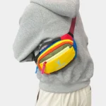 Petit sac banane nylon multicolore porté en bandoulière croisée, au style streetwear festif