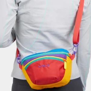 Sac banane colorblock multicolore en nylon porté en bandoulière de face, avec anneau de connexion en plastique violet
