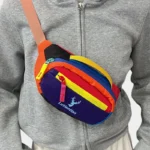Petit sac banane nylon multicolore colorblock porté en bandoulière de face au style streetwear festival
