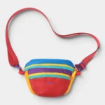 Sac banane colorblock en nylon multicolore posé de face, avec sangle et boucles ajustables en violet