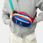 Petit sac banane nylon multicolore porté en bandoulière à la taille de face, au style streetwear colorblock