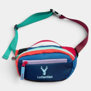 Petit sac banane nylon multicolore colorblock posé de face, avec sangle bicolore turquoise et bordeaux