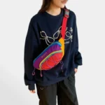 Sac banane multicolore porté en bandoulière par une femme de face au style streetwear colorblock