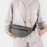 Sac Banane Technique Nylon Ripstop Imperméable Sac banane nylon quadrillé gris anthracite porté à la taille par une femme au style sportswear